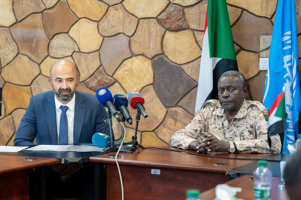 رئيس بعثة المنظمة الدولية للهجرة، محمد رفعت (إلى اليسار) يتحدث أثناء إعادة افتتاح مكتب المنظمة في الخرطوم.