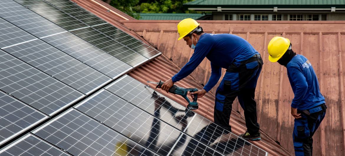 Trabajadores de PHILERGY, proveedor e instalador germano-filipino de energía solar, instalan paneles solares en una casa de Manila (Filipinas).