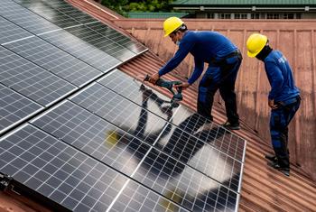 Trabajadores de PHILERGY, proveedor e instalador germano-filipino de energía solar, instalan paneles solares en una casa de Manila (Filipinas).