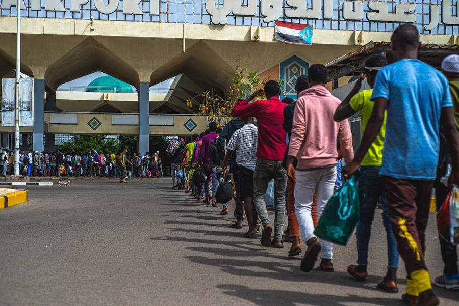 Uma fila de migrantes etíopes aguarda no aeroporto de Aden, no Iémen, por um voo de Retorno Humanitário Voluntário operado pela OIM.