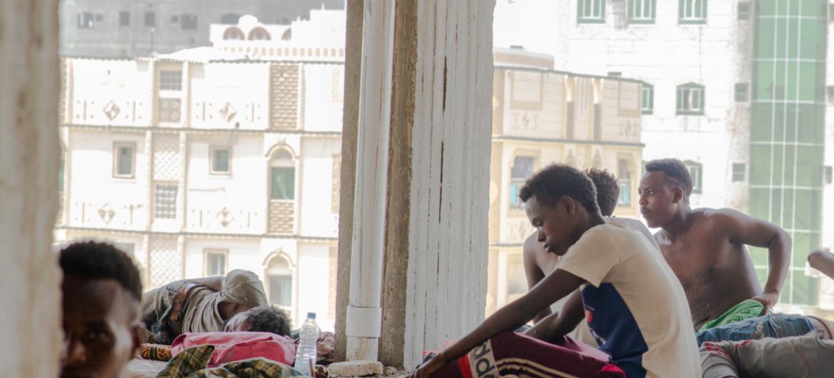 Dois migrantes descansam ao meio-dia à sombra em Aden, Iêmen.