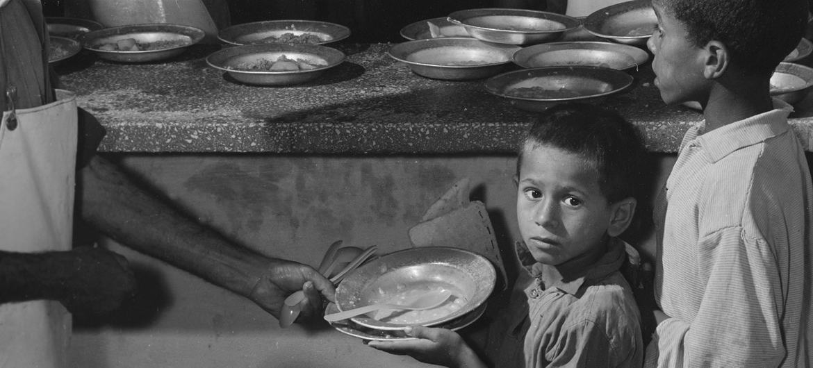 ARCHIVO: Niños refugiados palestinos reciben comidas calientes nutricionalmente equilibradas en un centro de alimentación suplementaria de la UNRWA en el campamento de Rafah, Franja de Gaza. (1969)