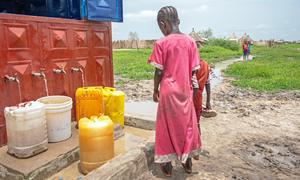 A girl collects water from a communal tap in the town of Renk, South Sudan. Since April 2023, over 810,000 people have crossed into the country from Sudan, many among them children.