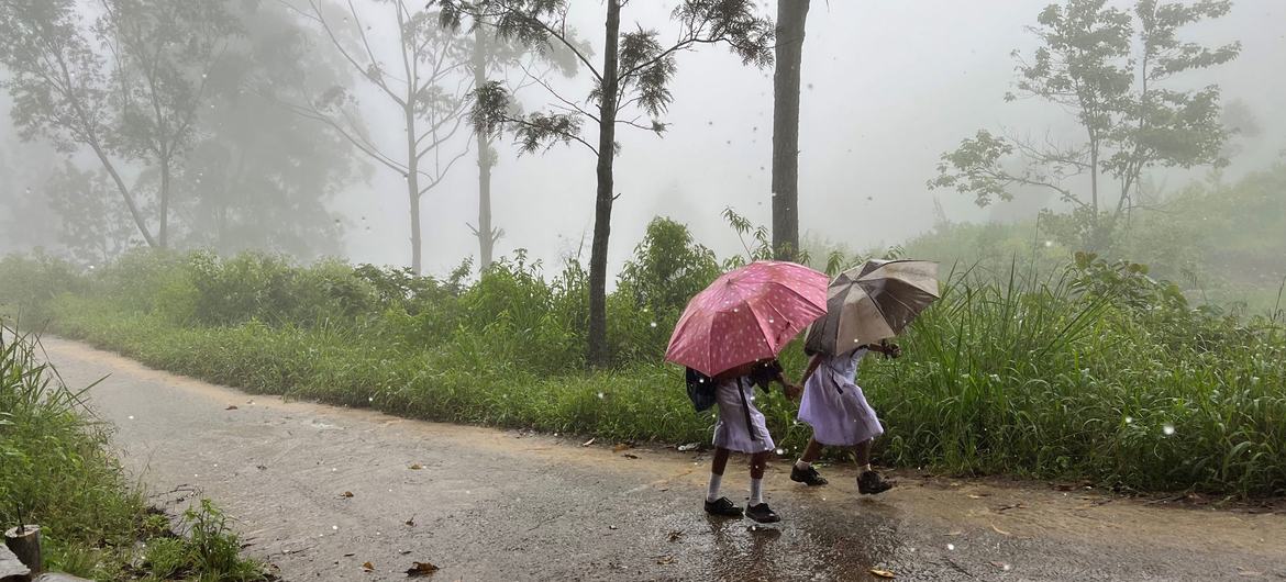 Schoolchildren head home for lunch despite the heavy rains, which have come early this year in Ramboda, Sri Lanka.
