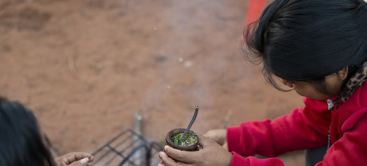 Teodora Vera y su hija comparten mate frente a su casa. Teodora es una mujer indígena rural, participante del proyecto PROEZA (Pobreza, Reforestación, Energía y Cambio Climático).