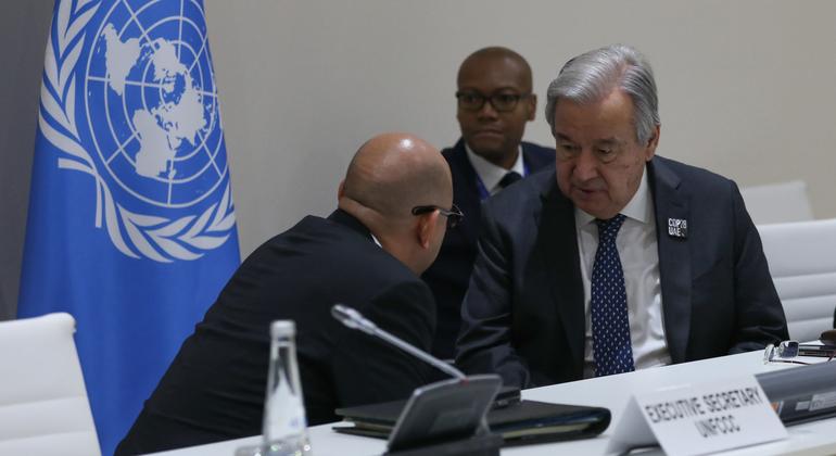UN Secretary-General António Guterres (right) and Simon Stiell, Executive Secretary of the UN Framework Convention on Climate Change (near left) speaking on the sidelines during the penultimate day of COP28.