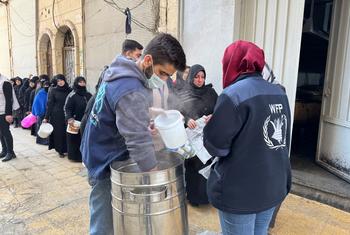 ڈبلیو ایف پی کا عملہ حلب میں کھانا تقسیم کر رہا ہے۔