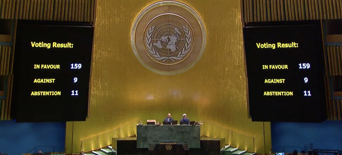 United Nations کے جنرل اسمبلی ہال کا منظر بڑی اسکرینوں پر ووٹنگ کا نتیجہ دکھا رہا ہے: حق میں 159، مخالفت میں 9، اور 11 غیر حاضر۔