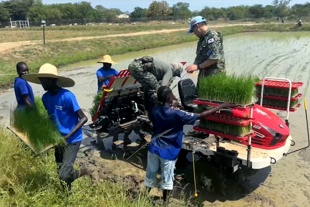 Walinda amani wa Korea Kusini wanawasaidia wakulima wa eneo hilo kwa mashine ya kupanda mpunga katika shamba lililofurika huko Bor, Sudan Kusini.