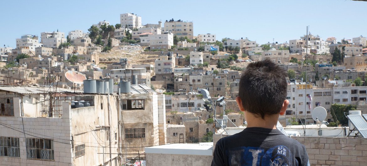 आठ वर्षीय हामिद, हेब्रॉन में अपने घर की छत से देख रहा है. (12 जुलाई, 2018)