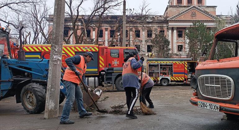 Des employés municipaux nettoient les rues malgré les bombardements à Mykolaïv. 