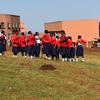 Wanafunzi kutoka Shule ya Upili ya Kakenya huko Kilgoris, Kenya, wamesimama katika uwanja wa shule wakiwa wamevaa sare nyekundu na bluu.