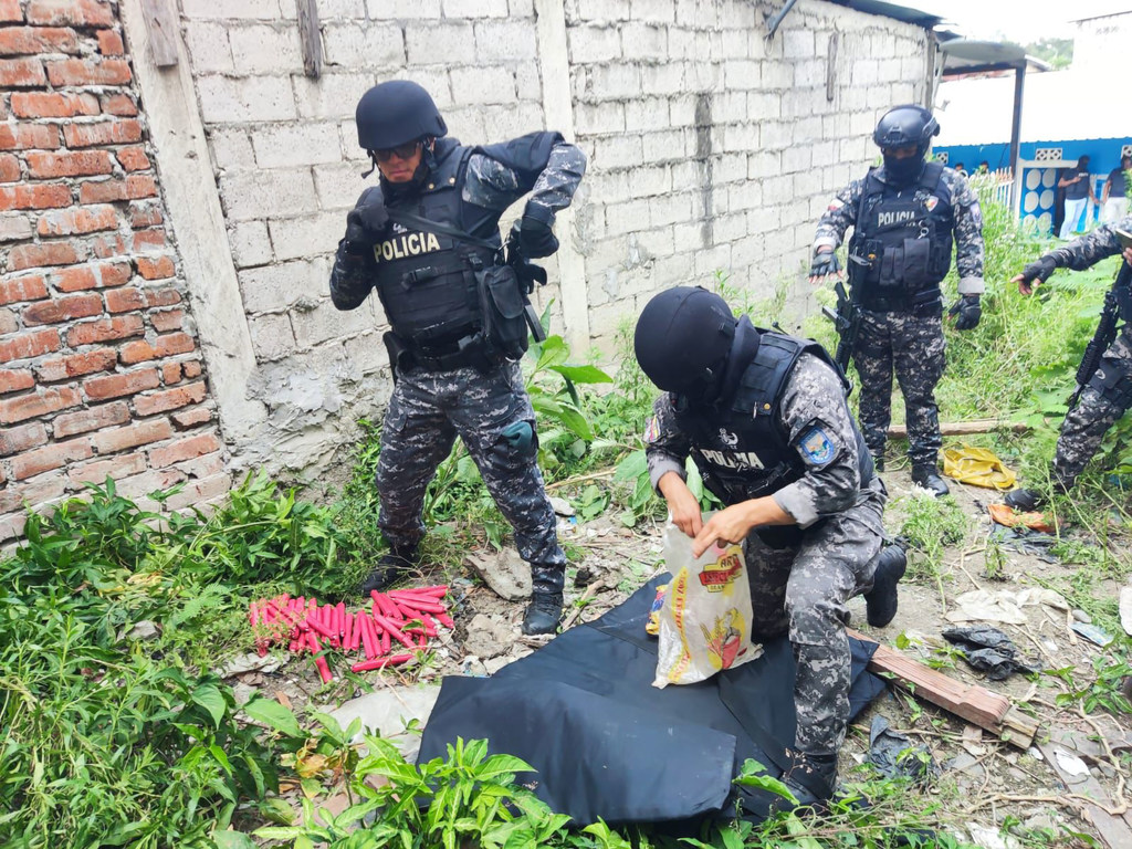 Agentes de la policía ecuatoriana, equipados con material táctico, aseguran una bolsa con fuegos artificiales confiscados durante un operativo policial en Santo Domingo de los Tsáchilas.