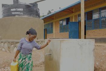 Mfanyikazi wa shule akichota maji ya kufanya usafi katika jengo hilo. Usafi umewezekana katika mashule kupitia mradi wa Maji unaofanikishwa na UNICEF na wadau wake.
