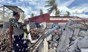 A woman and her baby stand in the rubble of Cyclone Idai, that struck central Mozambique in 2019.