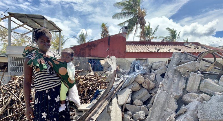 سيّدة تقف مع طفلها على أنقاض أحد المنازل المدمرة في موزامبيق عقب إعصار إيداي (2019).