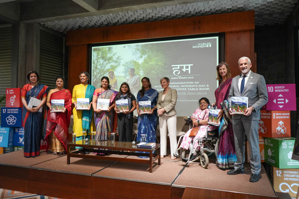 सतत विकास लक्ष्यों के चिह्नों से सजे मंच पर UN Women अधिकारियों और भारतीय महिला नेताओं ने एक नई पुस्तक का विमोचन किया।