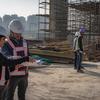 Workers discuss plans at a rapid transit construction site in Delhi, India.