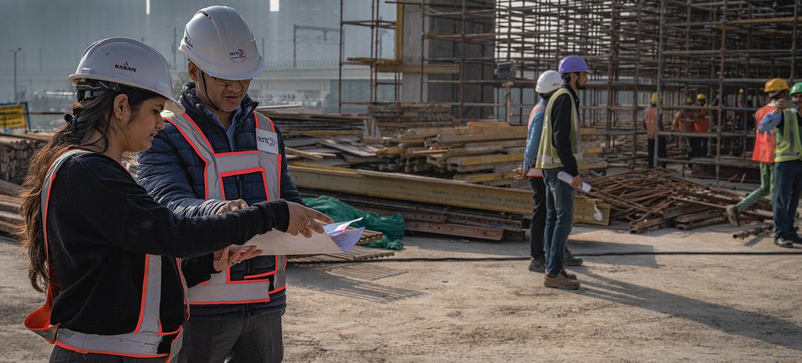 भारत की राजधानी दिल्ली में एक निर्माण स्थल पर कामगार बातचीत कर रहे हैं.