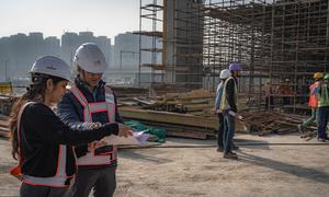 Workers discuss plans at a rapid transit construction site in Delhi, India.