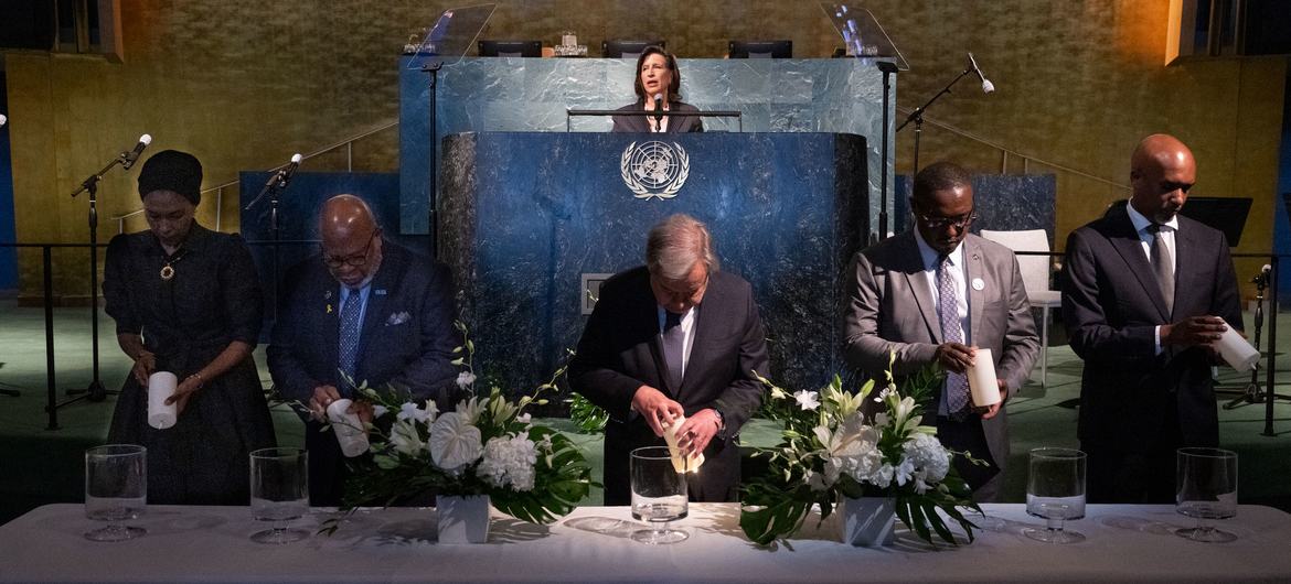 联合国秘书长安东尼奥·古特雷斯（中）和其他与会者在联合国大会纪念1994年卢旺达大屠杀30周年活动上点燃蜡烛。