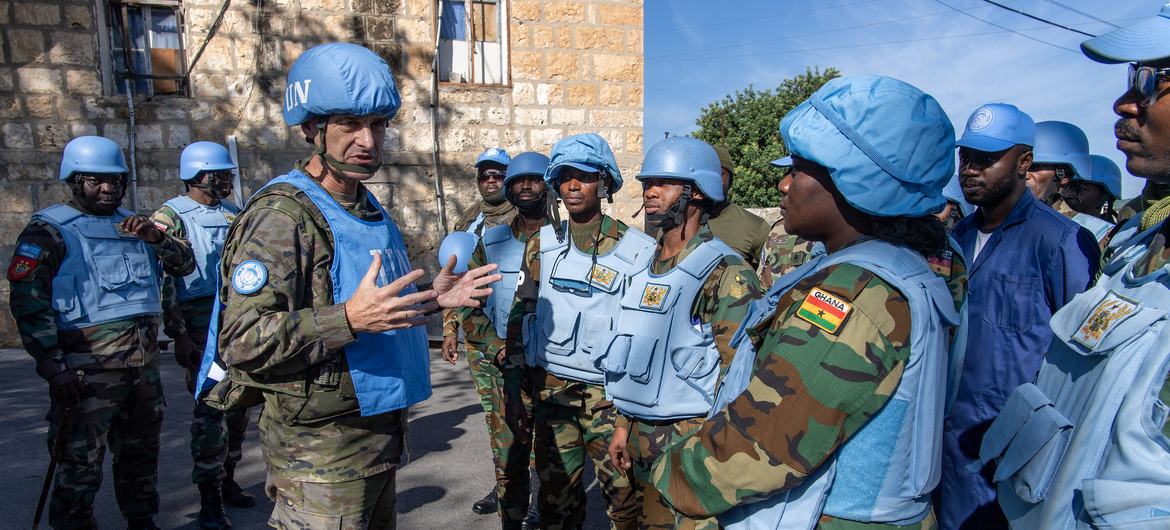 Un oficial de la UNIFIL informa a un grupo de cascos azules de Ghana en una calle del Líbano.