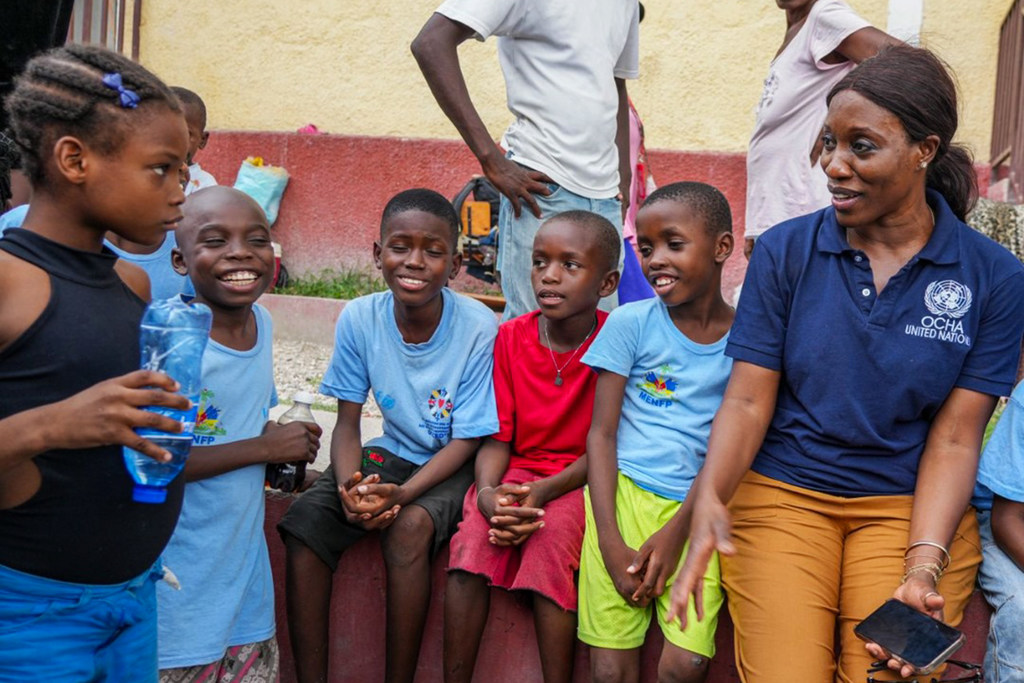 Edem Wosornu, Mkurugenzi wa Operesheni na Utetezi katika shirika la Umoja wa Mataifa la kutoa misaada ya dharura OCHA akiwa na watoto katika mji mkuu wa Haiti, Port-au-Prince.