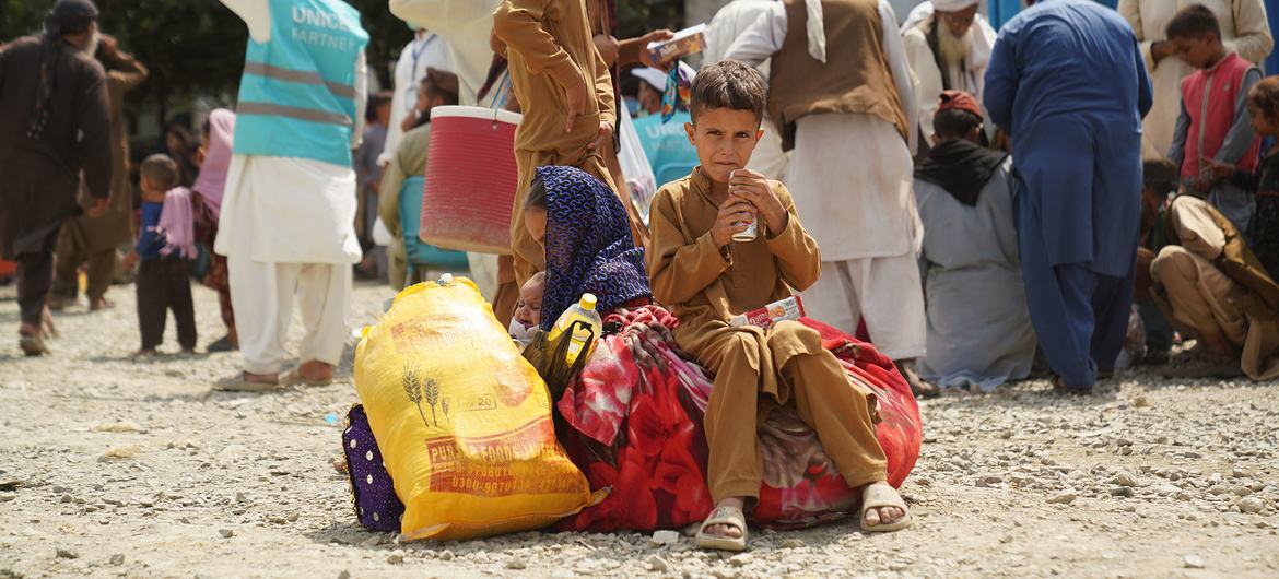 UNHCR staff assist Afghan families who have been returned from Pakistan at the Torkham border crossing in Afghanistan.
