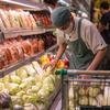 Funcionário arruma legumes em um supermercado na Indonésia