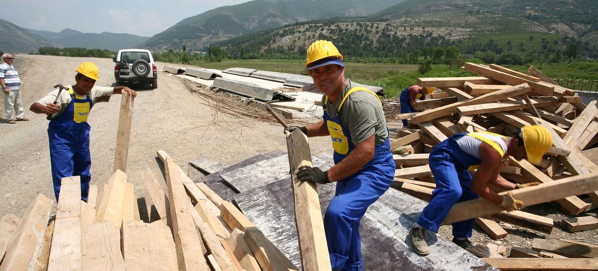 Erkekler Arnavutluk'ta yeni bir yol inşaatı üzerinde çalışıyorlar.
