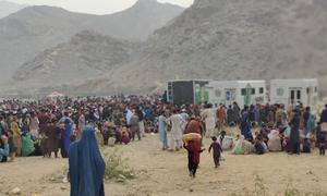 طورخم سرحد پر افغان پناہ گزین پاکستان کی نیشنل ڈیٹا بیس اینڈ رجسٹریشن اتھارٹی کی موبائل گاڑیوں کے قریب جانچ پڑتال کے انتظار میں بیٹھے ہیں۔