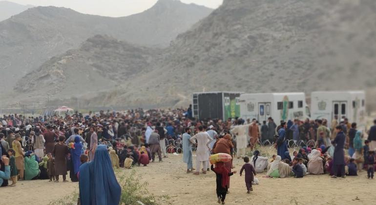 طورخم سرحد پر افغان پناہ گزین پاکستان کی نیشنل ڈیٹا بیس اینڈ رجسٹریشن اتھارٹی کی موبائل گاڑیوں کے قریب جانچ پڑتال کے انتظار میں بیٹھے ہیں۔