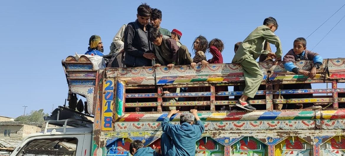 阿富汗难民家庭的孩子们爬上一辆开往阿富汗的卡车。