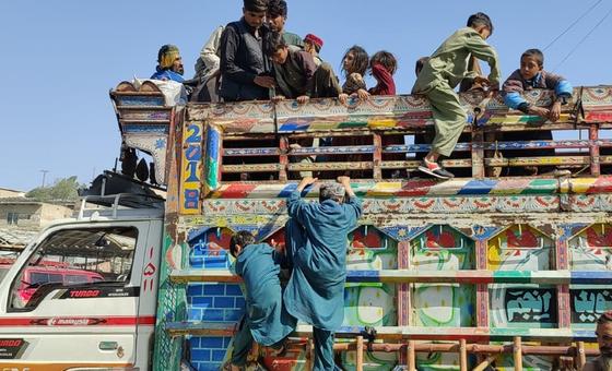 پناہ گزینوں کے بچے افغانستان واپسی کے لیے ٹرک پر سوار ہو رہے ہیں۔