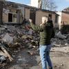 Une femme se tient au milieu des décombres et des ruines d'un bâtiment endommagé en Ukraine.
