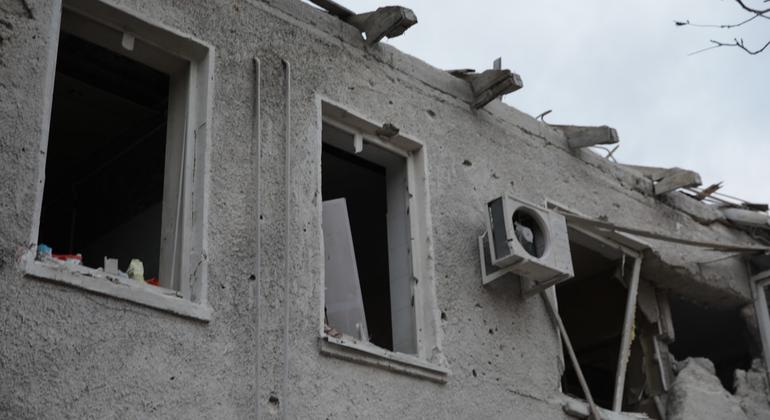 Поврежденное здание в Днепре, Украина, с разбитыми окнами и обломками после войны.
