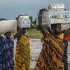 Unas mujeres transportan la ayuda alimentaria recibida en un punto de distribución de emergencia del PMA en Thaker, estado de Unity, Sudán del Sur (archivo).