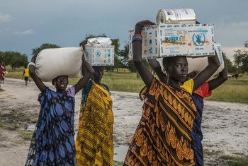 Unas mujeres transportan la ayuda alimentaria recibida en un punto de distribución de emergencia del PMA en Thaker, estado de Unity, Sudán del Sur (archivo).