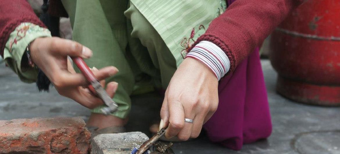 ایک خاتون کارکن گھر سے زیورات تیار کر رہی ہیں۔