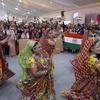 WCH 2025 हॉल में एक उत्सव के दौरान उदार भारतीय पोशाकों का प्रदर्शन कर रहे हैं, जो यूनेल्फो के अटल सांस्कृतिक विरासत सूची पर स्थित है, एक भीड़ के साथ पृष्ठभूमि में भारतीय झंडे हिलाते हैं.