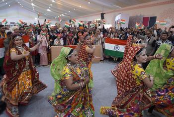 WCH 2025 हॉल में एक उत्सव के दौरान उदार भारतीय पोशाकों का प्रदर्शन कर रहे हैं, जो यूनेल्फो के अटल सांस्कृतिक विरासत सूची पर स्थित है, एक भीड़ के साथ पृष्ठभूमि में भारतीय झंडे हिलाते हैं.