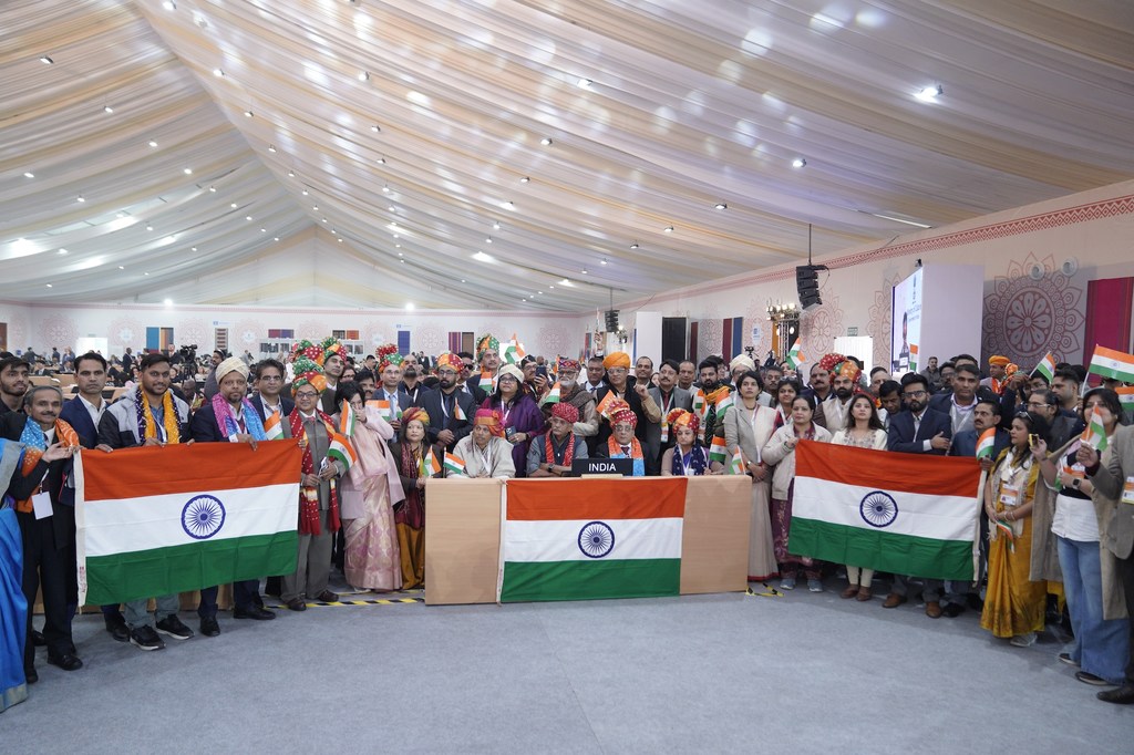 आईसीएच 2025 सम्मेलन में भारतीय प्रतिनिधिमंडल भारतीय ध्वज लिए और पारंपरिक पोशाक पहने हुए।
