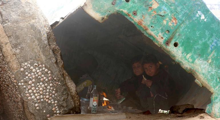 مع هطول الأمطار على غزة، يلجأ الأطفال إلى الجلوس تحت قارب صيد معطّل كأحد الأماكن القليلة التي توفر لهم مأوى في منطقة النزوح المزدحمة.