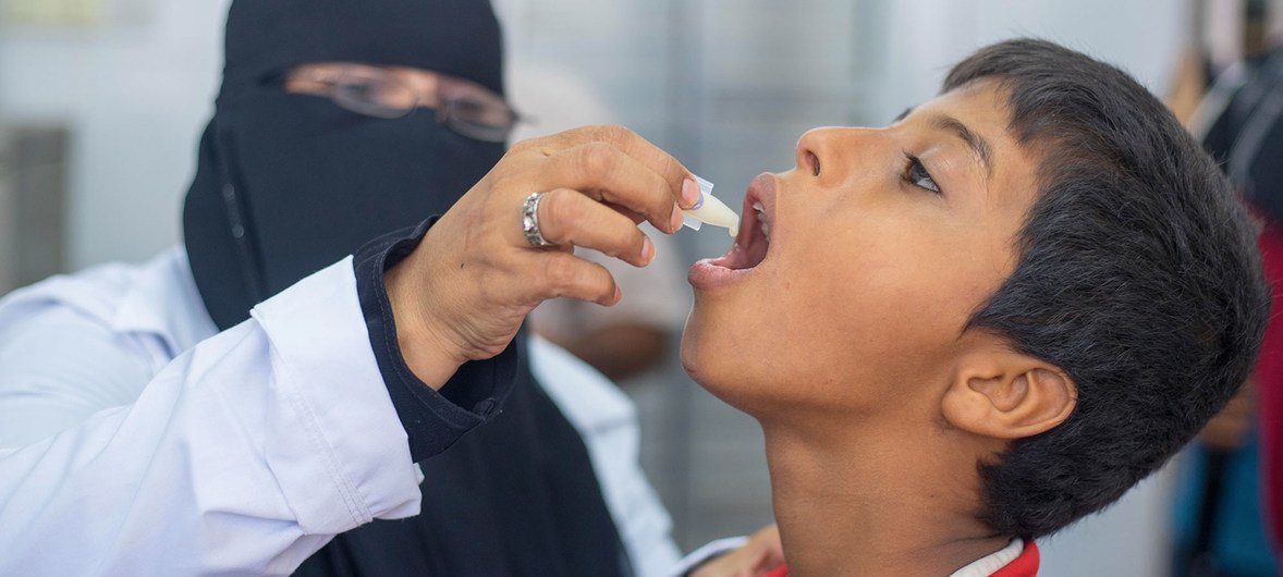 Un agent de santé administre un vaccin contre le choléra à un jeune garçon au Yémen.