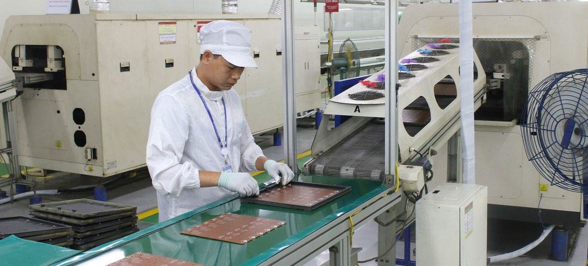 Um trabalhador verifica placas de circuito em uma fábrica de eletrônicos na província de Hung Yen, Vietnã