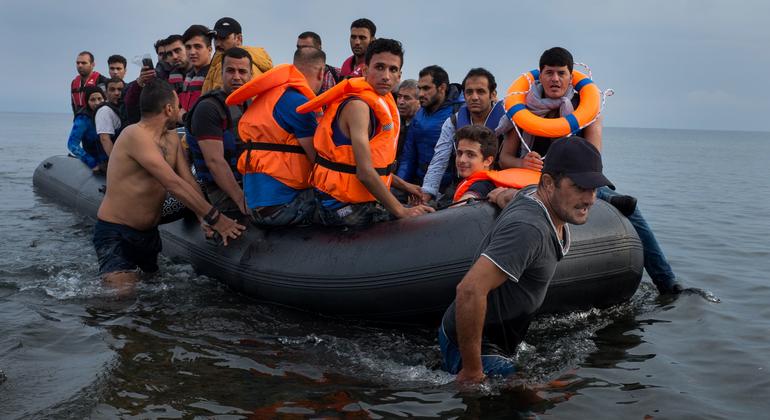 शरणार्थियों से भरी रबर की एक बड़ी नाव को उत्तरी ईजियन क्षेत्र के लेस्बोस द्वीप के तट पर खींचे जाते हुए.