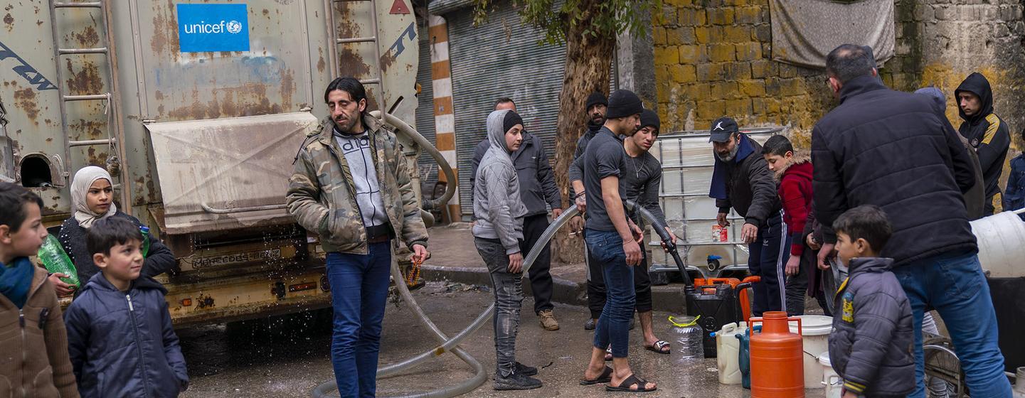 Families fill jerrycans with clean water at a distribution point in Almyassar neighbourhood, Aleppo city, in northern Syria.