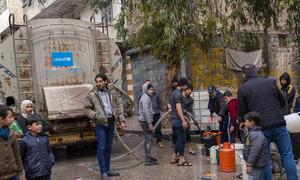 Families fill jerrycans with clean water at a distribution point in Almyassar neighbourhood, Aleppo city, in northern Syria.