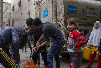 सीरिया के अलेप्पो में, भूकम्प प्रभावित समुदाय, एक पाइप के ज़रिए पानी हासिल करते हुए.