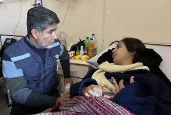 دكتور أحمد المنظري المدير الإقليمي لمنظمة الصحة العالمية لإقليم شرق المتوسط، يستمع إلى شابة مصابة بسبب الزلزال في اللاذقية، سوريا